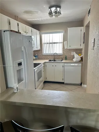 a kitchen with stainless steel appliances a sink stove and refrigerator