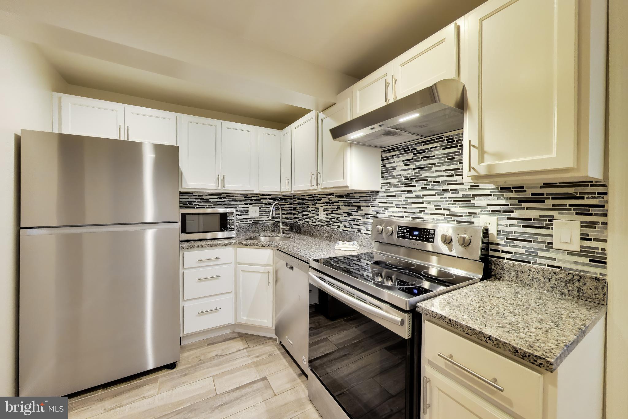 9200 Linden Grove Court Silver Spring, MD 20910 - Photo 43 of 72 a kitchen with a stove a sink and a refrigerator