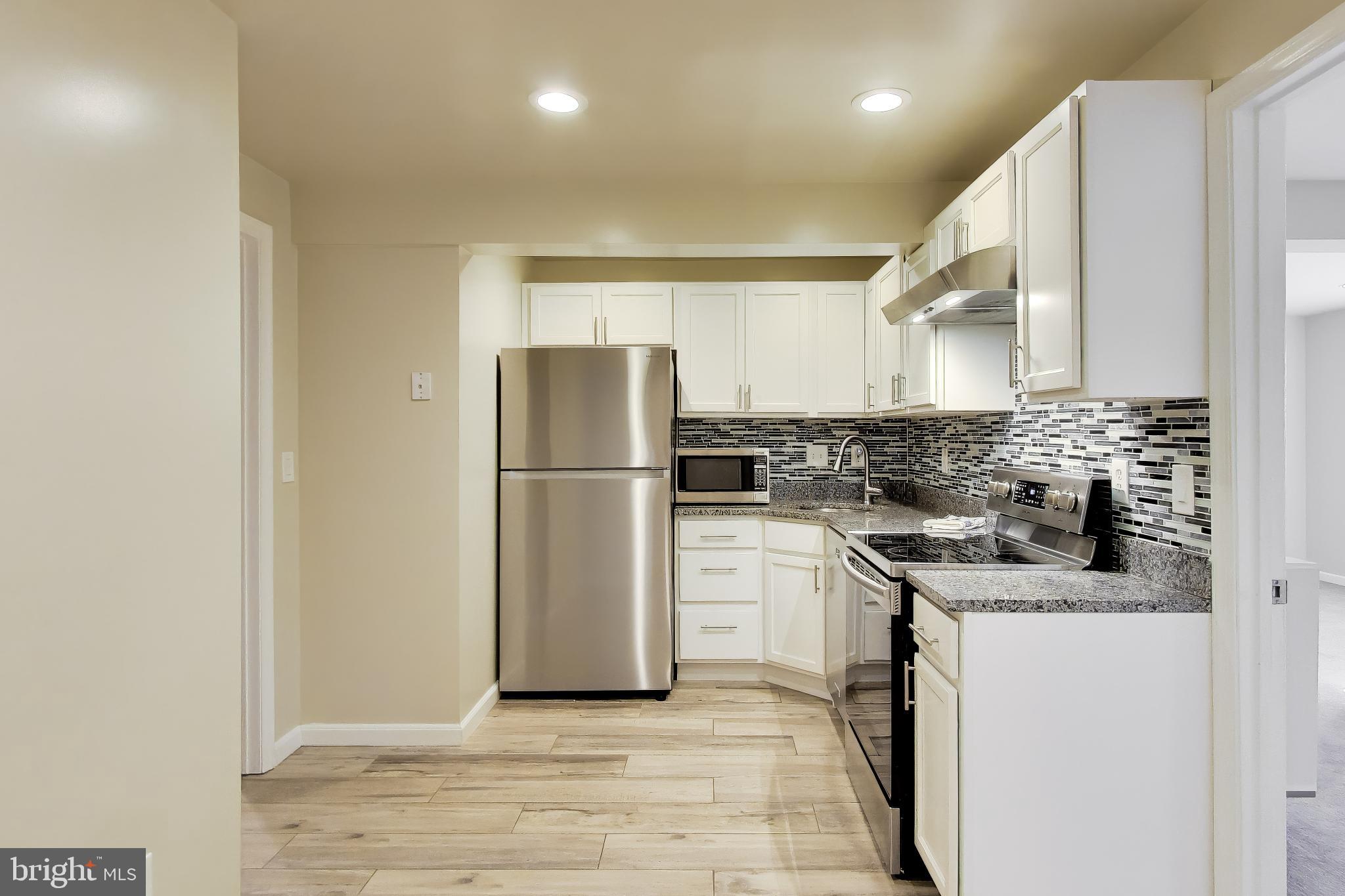 9200 Linden Grove Court Silver Spring, MD 20910 - Photo 45 of 72 a kitchen with a refrigerator sink stove and cabinets