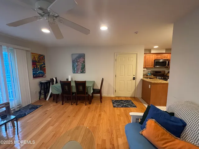 a living room with furniture and a dining table with wooden floor