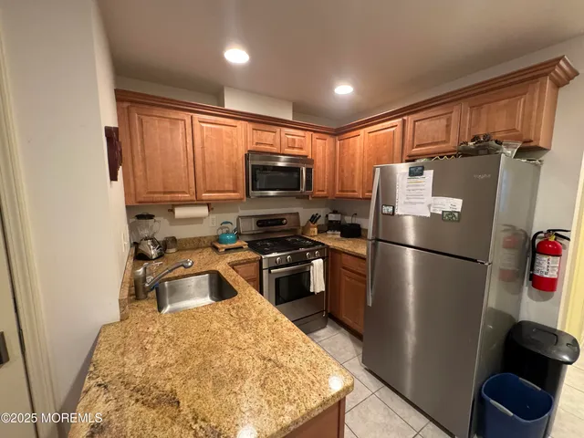 a kitchen with stainless steel appliances granite countertop a refrigerator stove top oven a sink and dishwasher