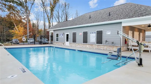 a view of a house with pool and chairs