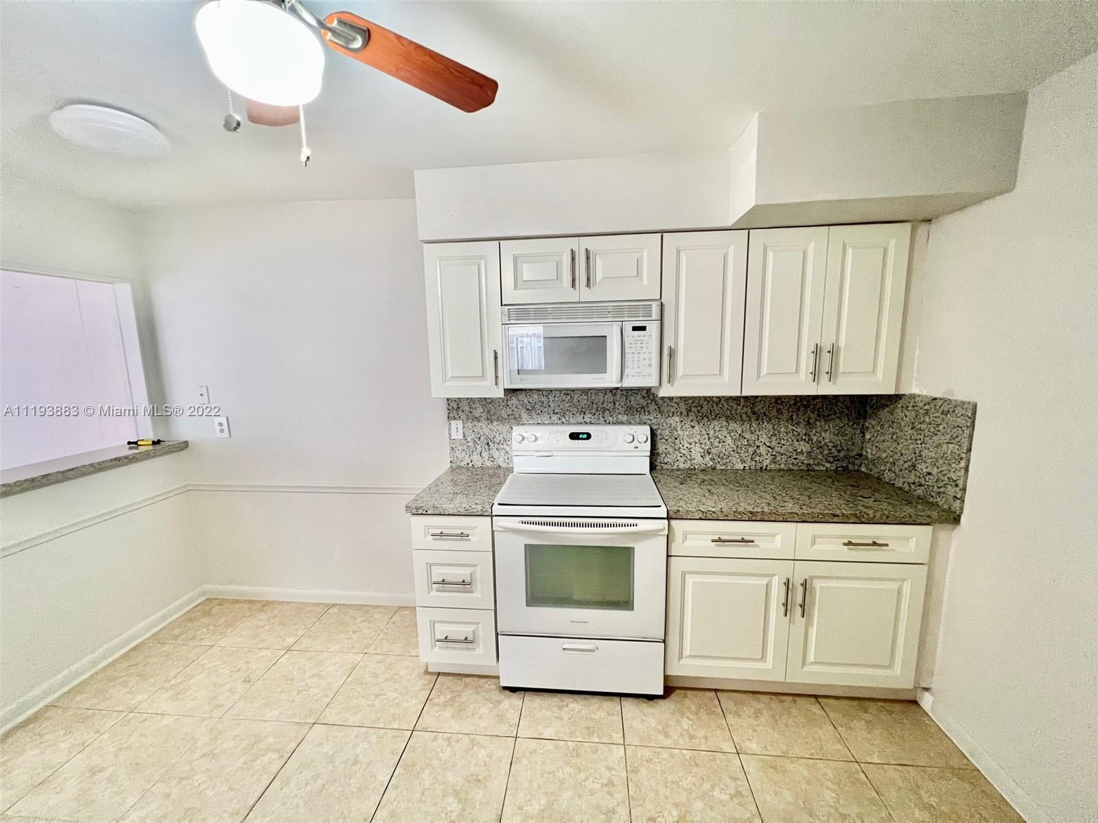 4407 Arthur Street Hollywood, FL 33021 - Photo 13 of 25 a kitchen with white cabinets appliances and a sink