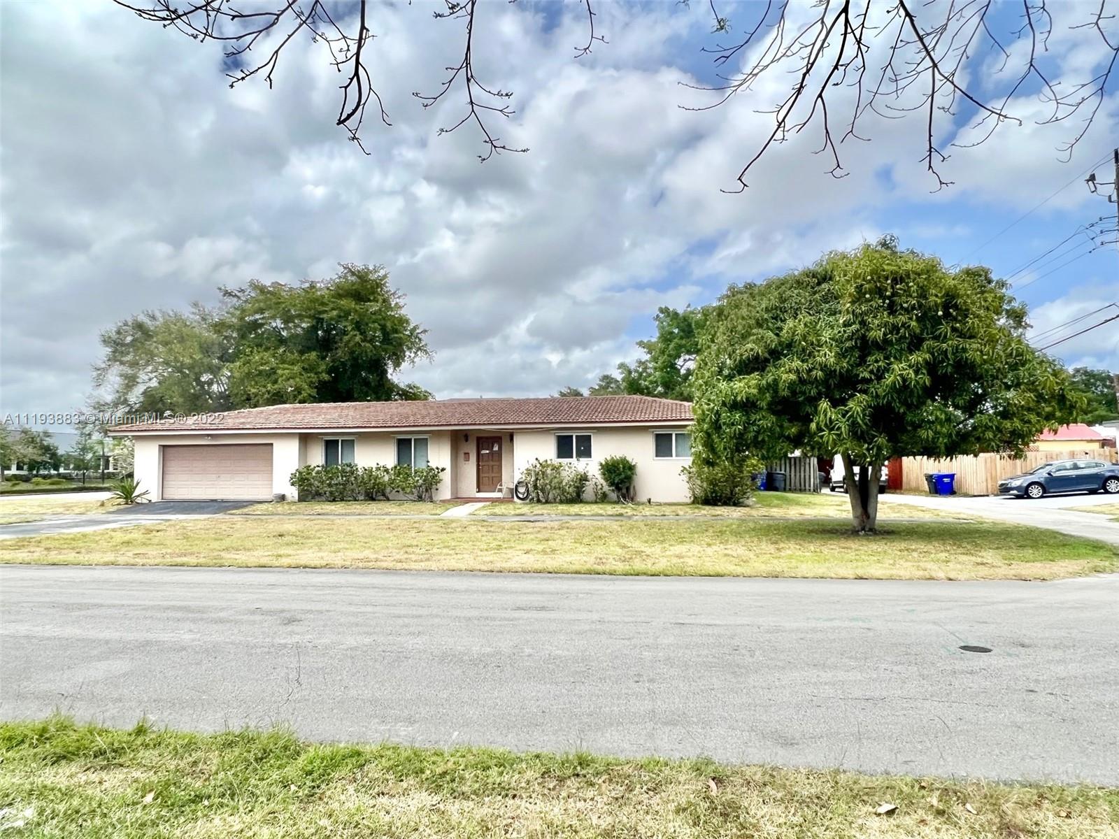 4407 Arthur Street Hollywood, FL 33021 - Photo 2 of 25 a view of a house with a yard and large trees