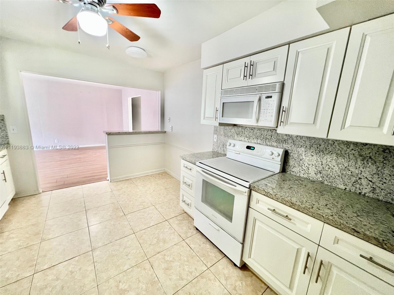 4407 Arthur Street Hollywood, FL 33021 - Photo 4 of 25 a kitchen with stainless steel appliances granite countertop a sink and cabinets