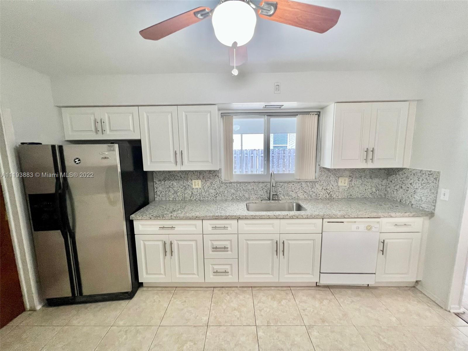 4407 Arthur Street Hollywood, FL 33021 - Photo 5 of 25 a kitchen with stainless steel appliances granite countertop a refrigerator a sink a stove with white cabinets
