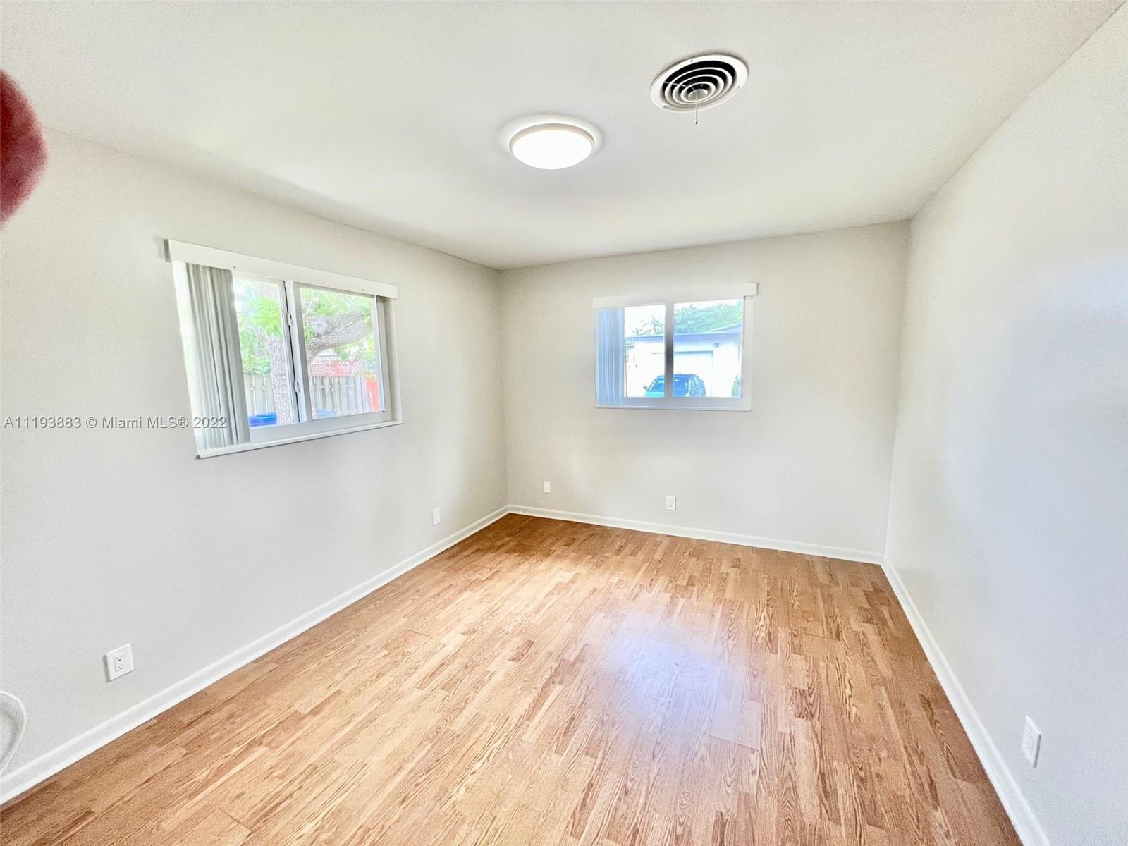 4407 Arthur Street Hollywood, FL 33021 - Photo 8 of 25 an empty room with wooden floor and windows