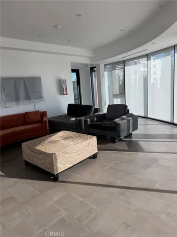 a living room with furniture and floor to ceiling window