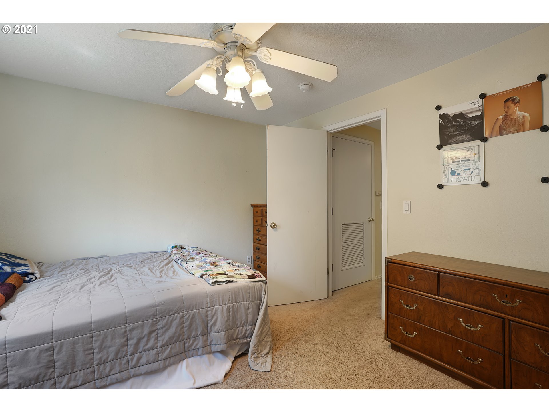 12648 Southeast Foster Road, Unit 10B Portland, OR 97236 - Photo 21 of 22 a bedroom with a bed and a chandelier