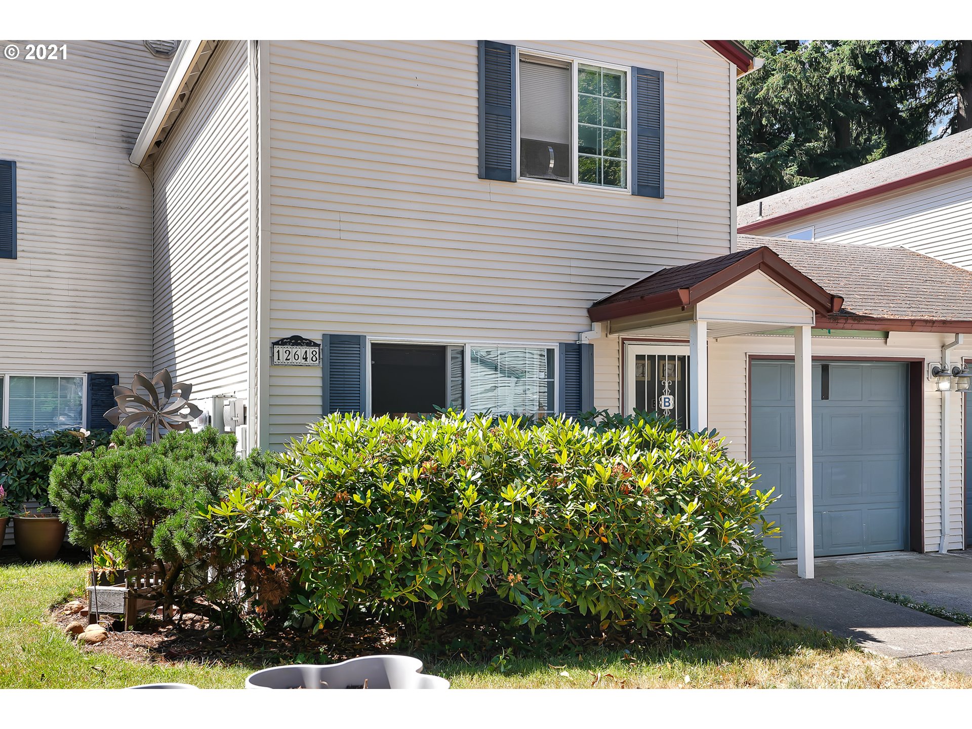 12648 Southeast Foster Road, Unit 10B Portland, OR 97236 - Photo 3 of 22 a front view of a house with a garden