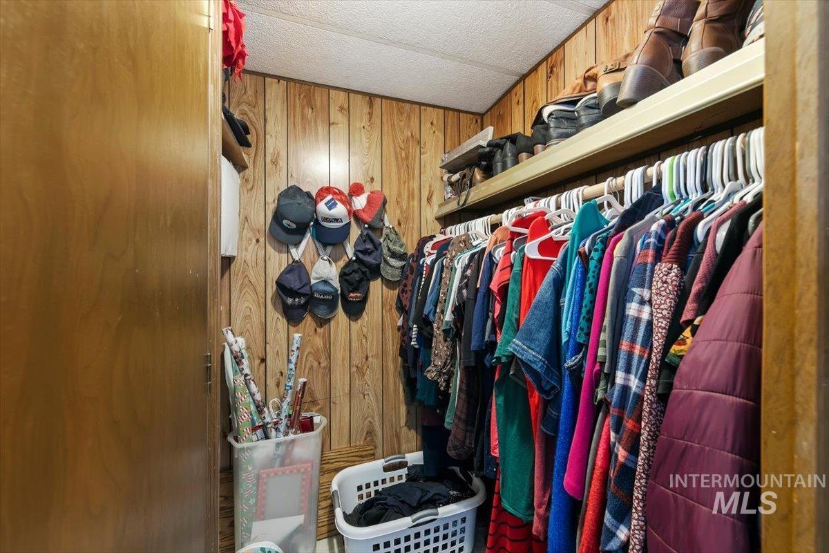 915 South Curtis Road, Unit 68 Boise City, ID 83705 - Photo 12 of 20 Wood-paneled wall, built-in shelving, and clothes hanging rod