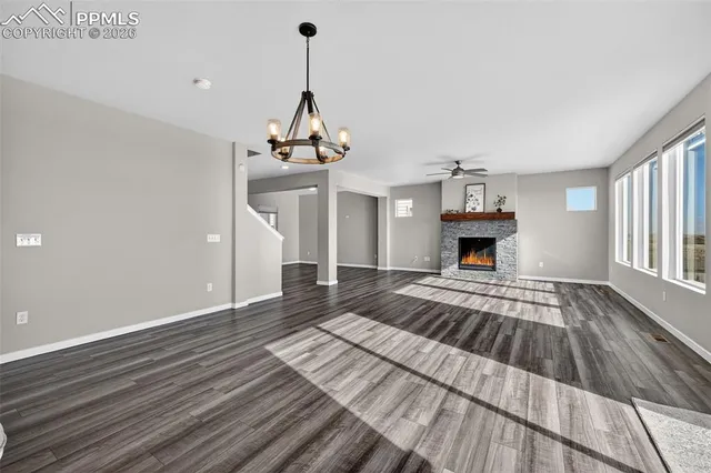 a view of empty room with wooden floor and fireplace