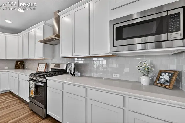 a kitchen with stainless steel appliances granite countertop white cabinets and stove