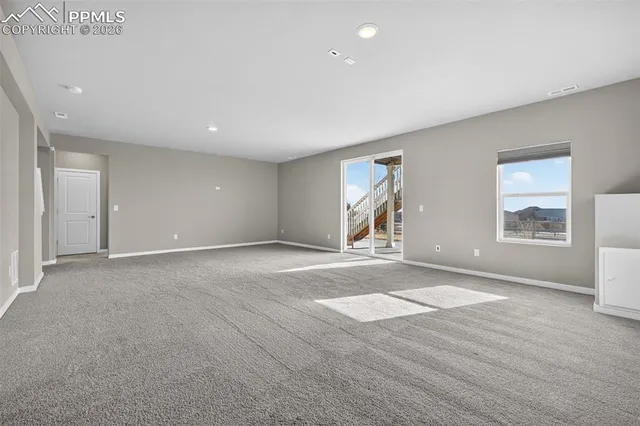 an empty room with windows and entrance