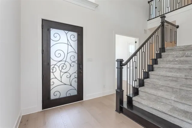 a view of a big room with wooden floor and windows