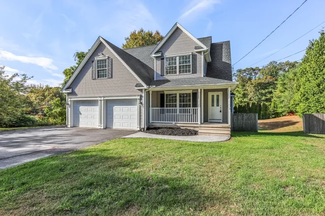 a front view of a house with a garden and yard