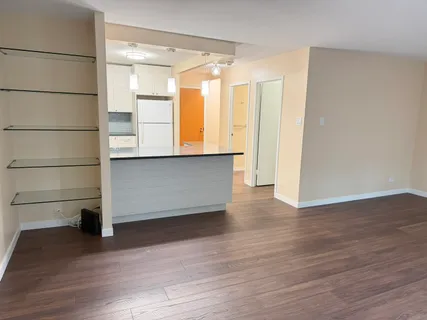 a view of empty room with wooden floor and cabinet
