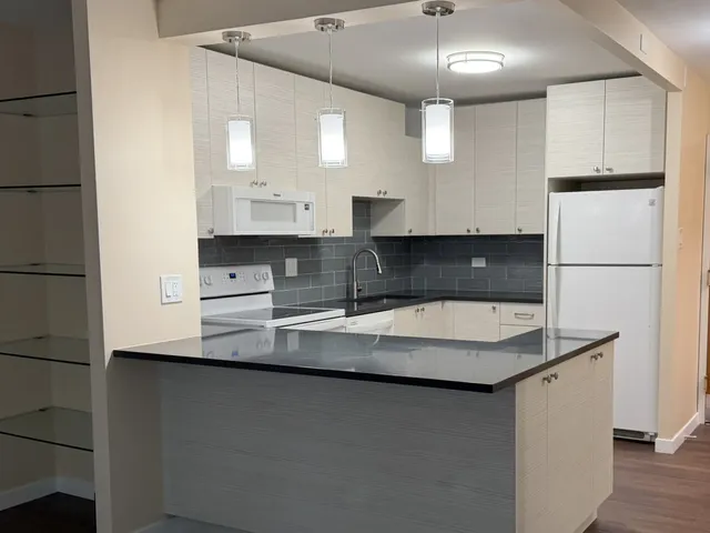 a kitchen with stainless steel appliances granite countertop a sink a refrigerator and a stove