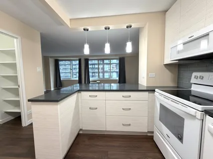 a kitchen with granite countertop white cabinets and white appliances