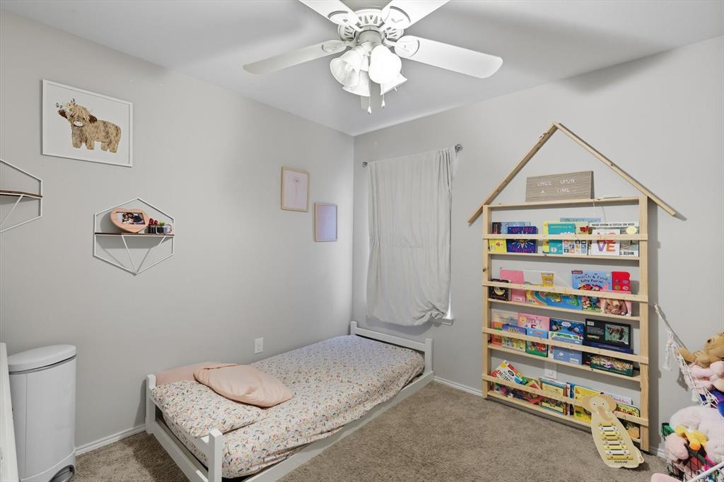 14564 Serrano Ridge Road Fort Worth, TX 76052 - Photo 18 of 29 a bedroom with a bed and a chandelier