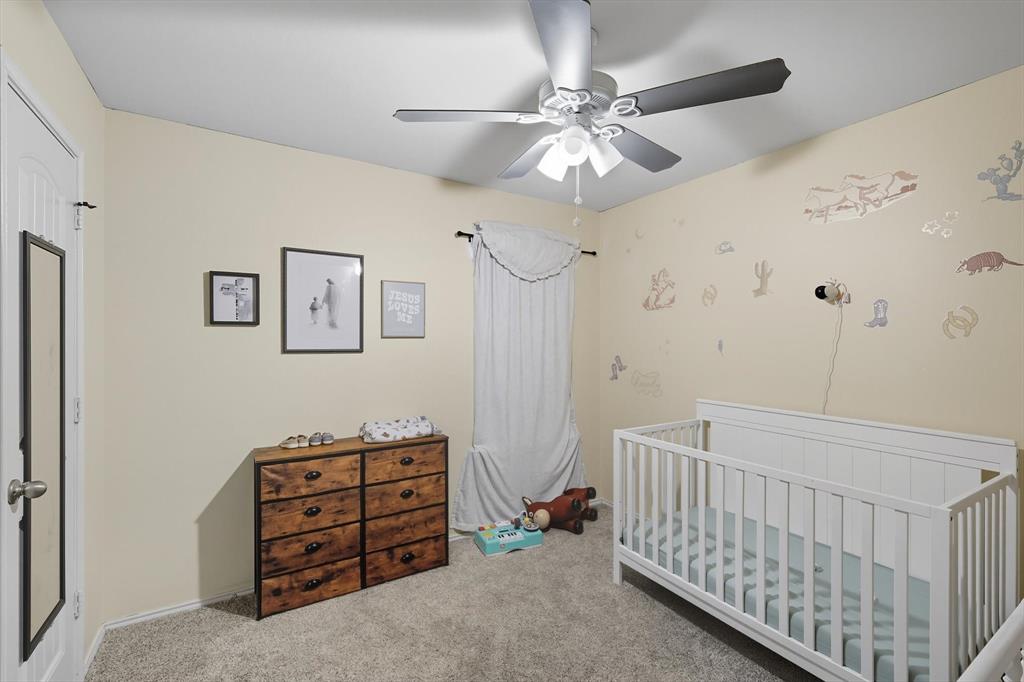 14564 Serrano Ridge Road Fort Worth, TX 76052 - Photo 20 of 29 a bedroom with a bed and a chandelier