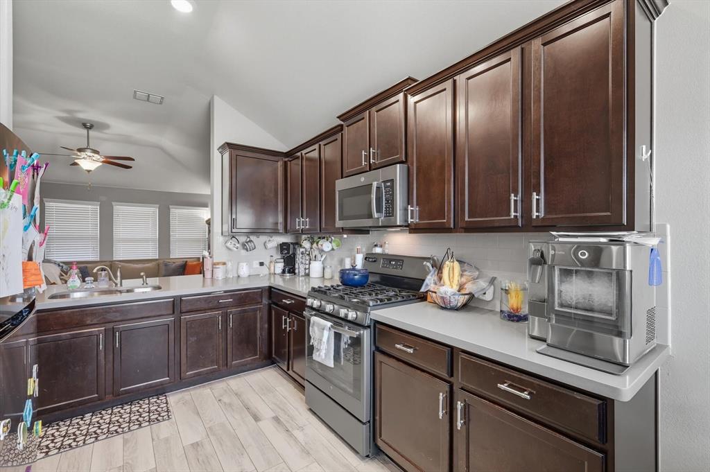 14564 Serrano Ridge Road Fort Worth, TX 76052 - Photo 7 of 29 a kitchen with stainless steel appliances granite countertop a sink stove and cabinets