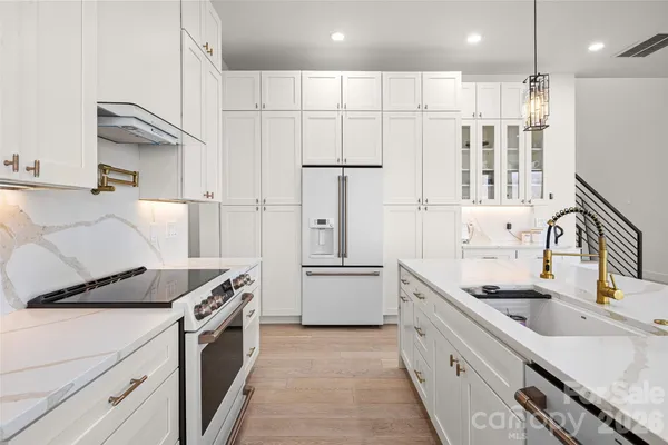 a kitchen with stainless steel appliances granite countertop a sink stove and refrigerator