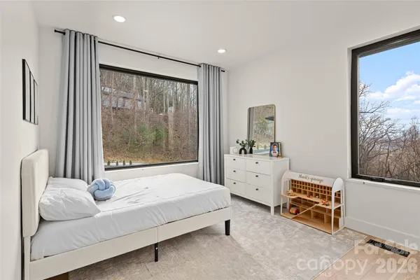 a bedroom with furniture and a large window