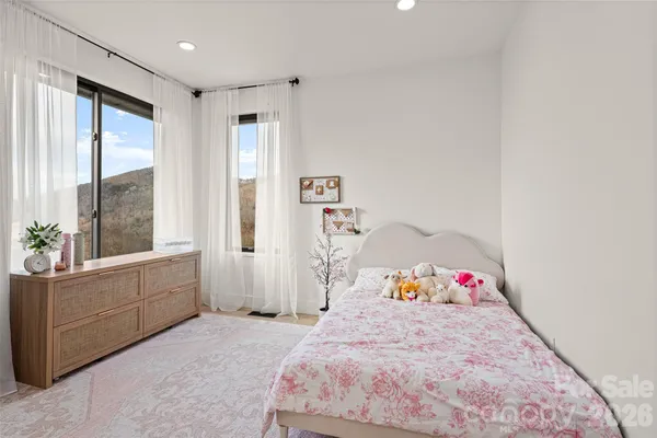 a spacious bedroom with a bed and a window