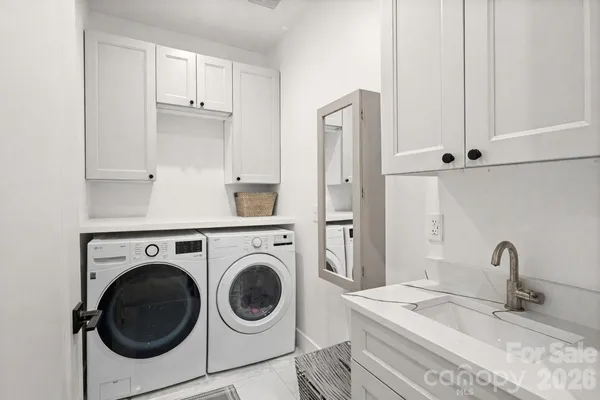 a utility room with sink dryer and washer