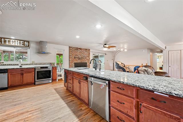 1263 York Road Colorado Springs, CO 80918 - Photo 29 of 29 Kitchen with brown cabinetry, open floor plan, light stone countertops, appliances with stainless steel finishes, and recessed lighting