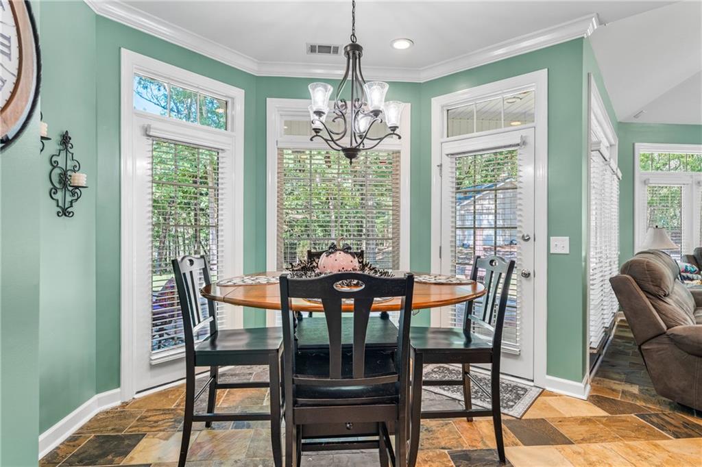 642 Nuckols Road Seale, AL 36875 - Photo 20 of 48 Bay window dining area with transom windows, a multi-light chandelier, and large format floor tile