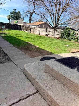 a front view of house with yard and trees in the background