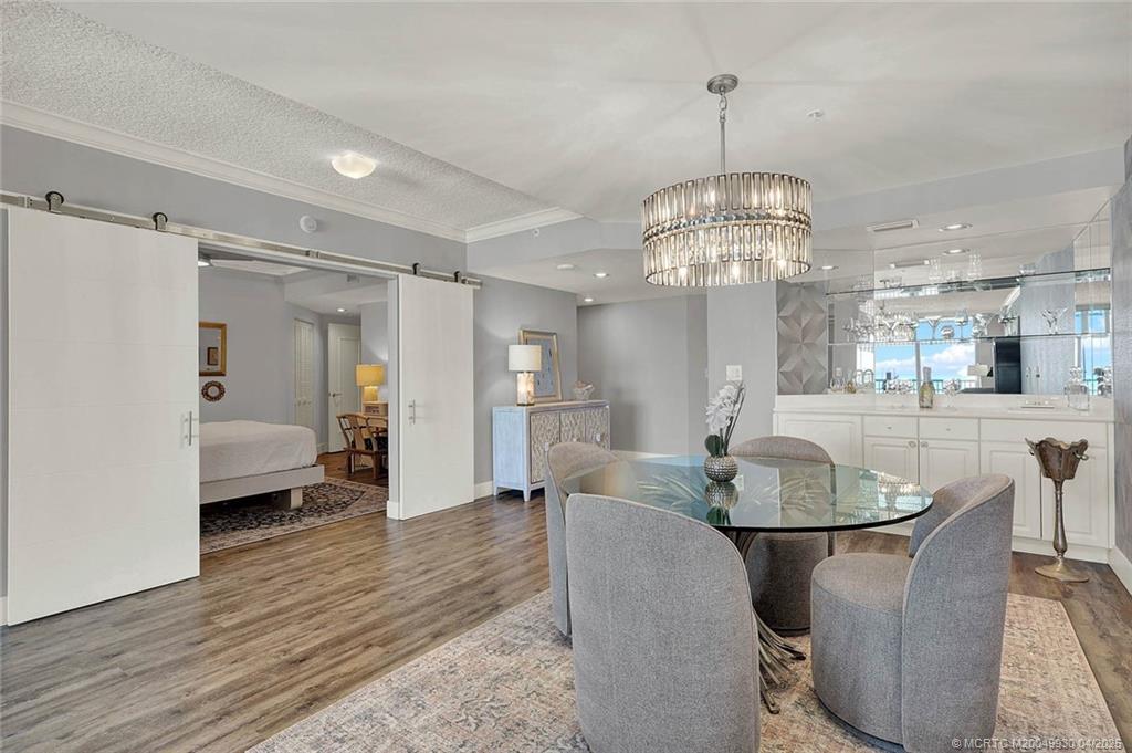 8600 South Ocean Drive, Unit LN3 Jensen Beach, FL 34957 - Photo 12 of 63 a dining room with wooden floor a chandelier a glass table and chairs