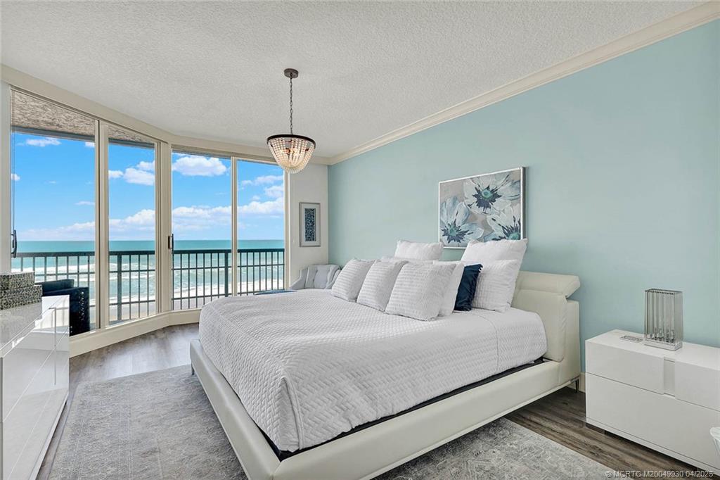 8600 South Ocean Drive, Unit LN3 Jensen Beach, FL 34957 - Photo 27 of 63 a bedroom with a large bed and a chandelier