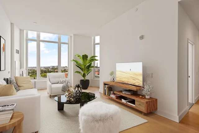 a living room with furniture flat screen tv and a large window
