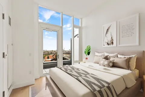 a bedroom with a balcony a bed and a painting on the wall