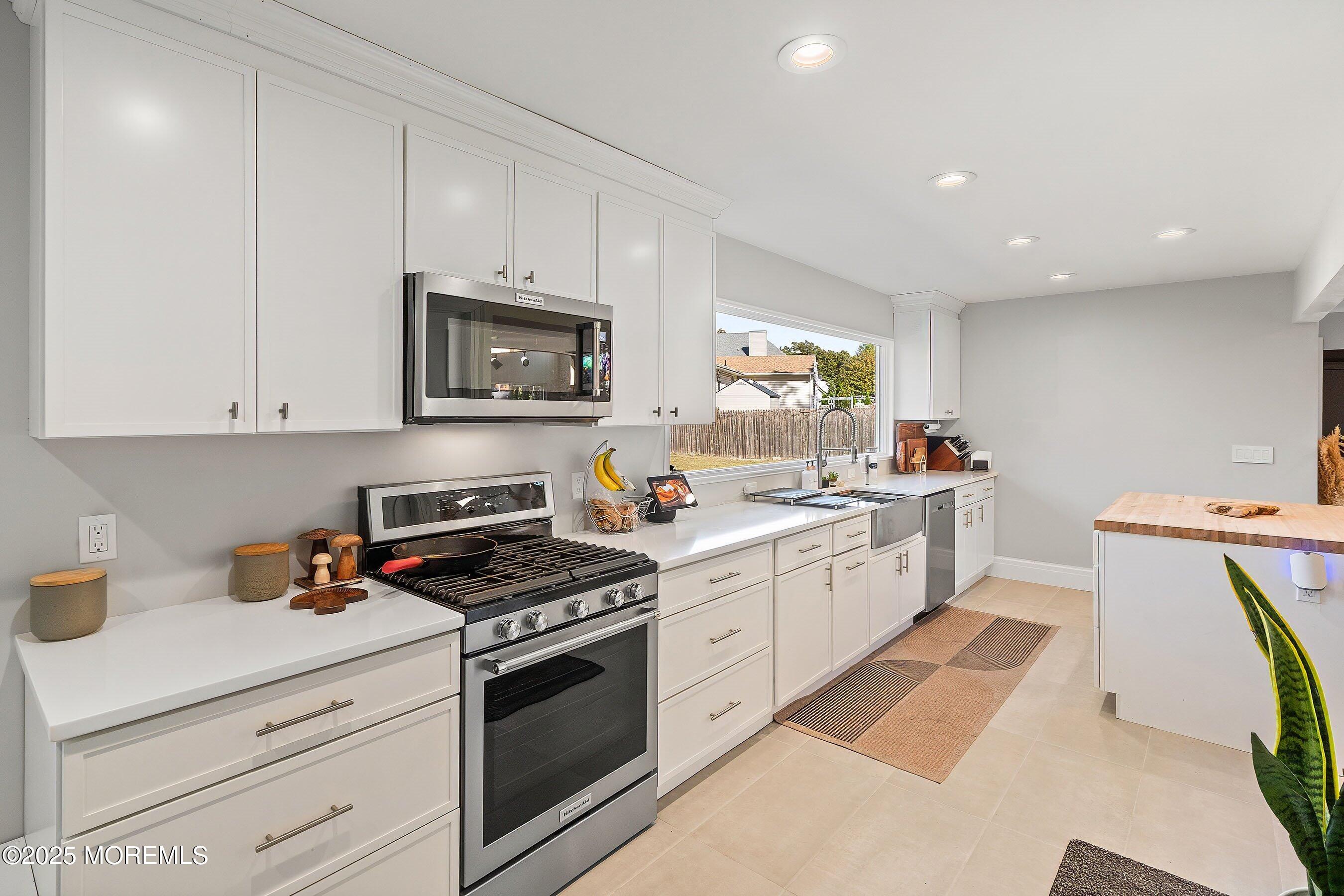 409 Aldrich Road Howell, NJ 07731 - Photo 11 of 27 a kitchen with a stove a sink and a microwave