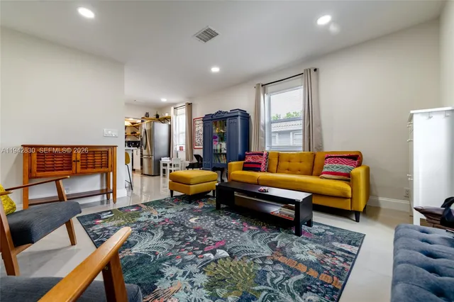 a living room with furniture a rug and a lamp