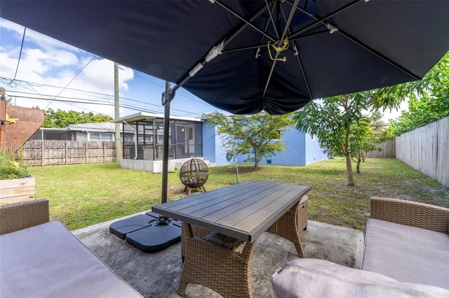a view of a yard with plants and a bench