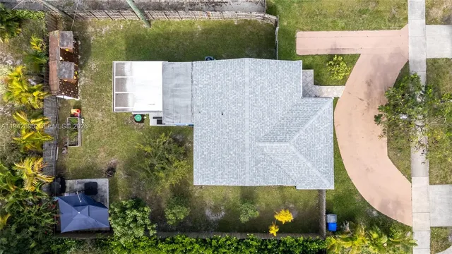 an aerial view of residential houses with outdoor space and trees