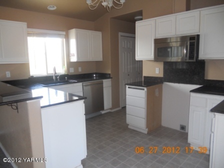 15721 Fisk Road Yakima, WA 98908 - Photo 2 of 9 a kitchen with granite countertop white cabinets and stainless steel appliances