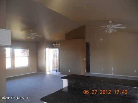15721 Fisk Road Yakima, WA 98908 - Photo 6 of 9 an empty room with windows and ceiling fan