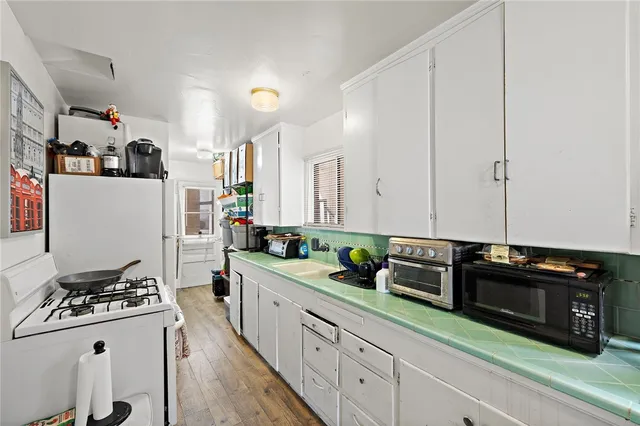 a kitchen with granite countertop a sink stove and cabinets