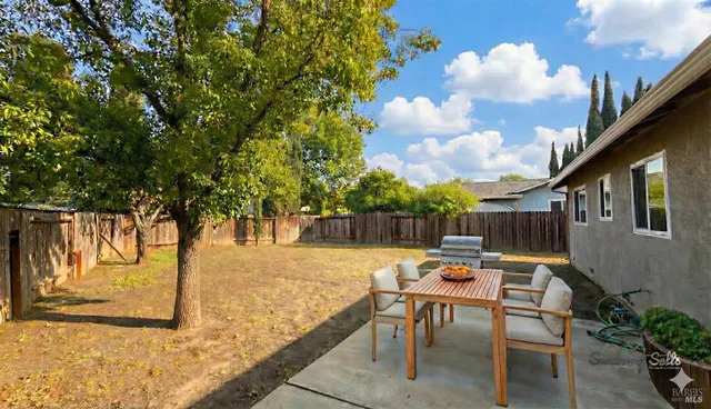a backyard of a house with table and chairs