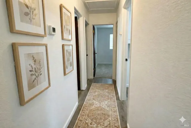 view of a hallway with wooden floor and closet