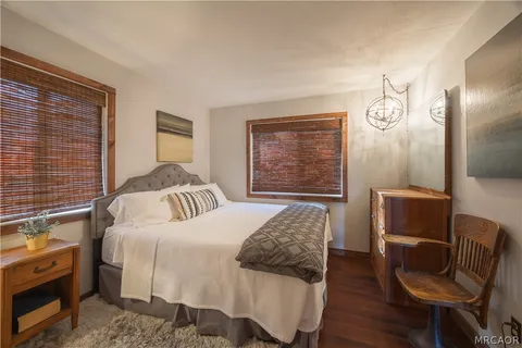 a bedroom with a bed and a chair with the outer view