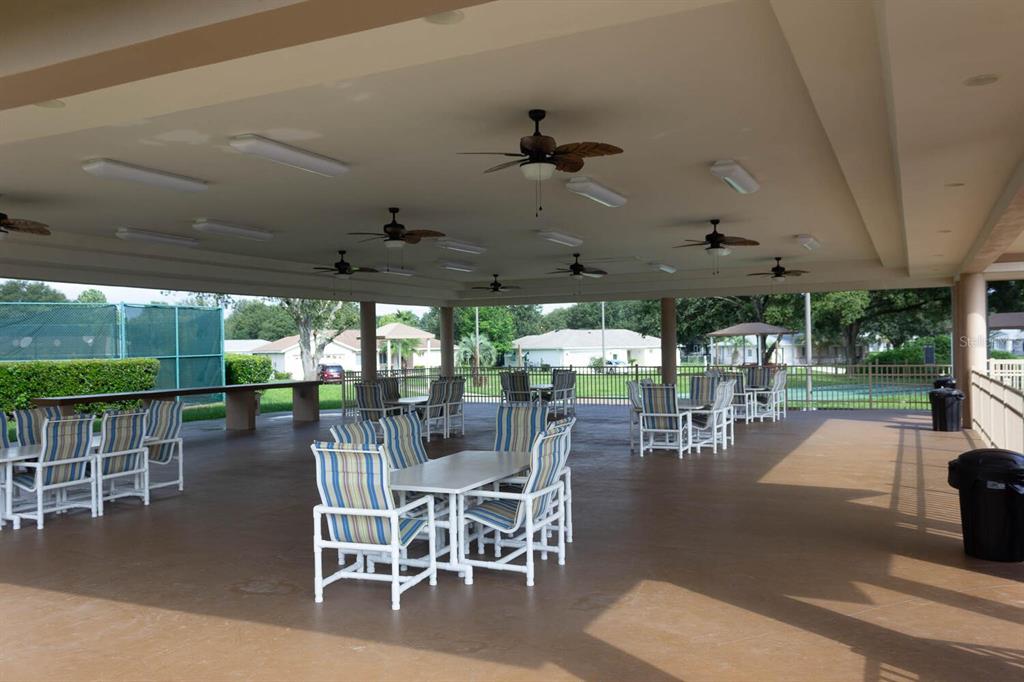 6086 Southwest 98th Loop Ocala, FL 34476 - Photo 43 of 49 a outdoor space with lots of tables a large window and chairs