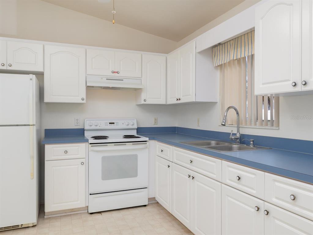 6086 Southwest 98th Loop Ocala, FL 34476 - Photo 8 of 49 a kitchen with white cabinets and white appliances