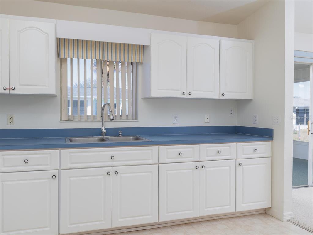 6086 Southwest 98th Loop Ocala, FL 34476 - Photo 9 of 49 a kitchen with granite countertop white cabinets and a sink
